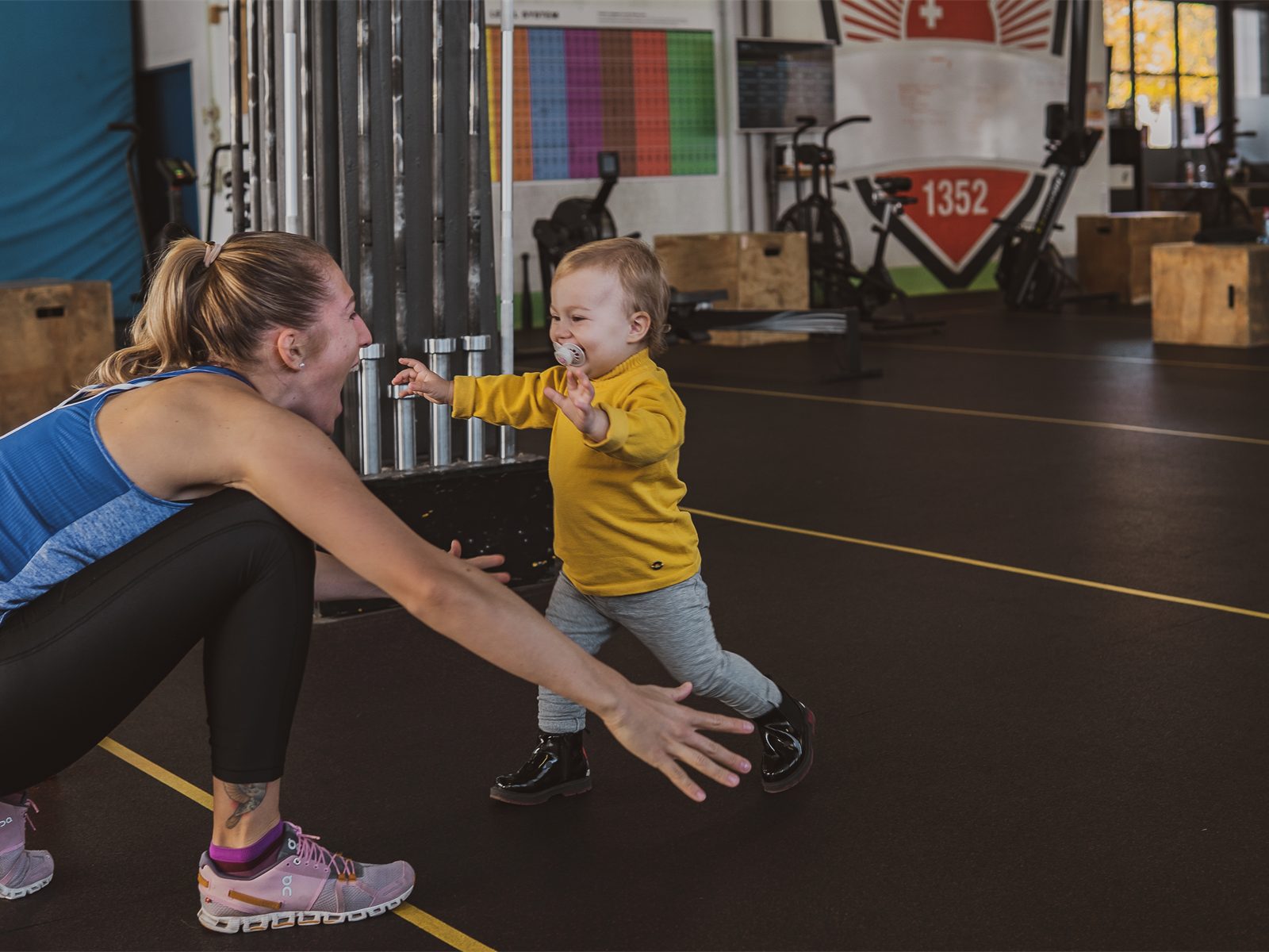 Mama spielt mit ihrem Kleinkind in der Trainingshalle